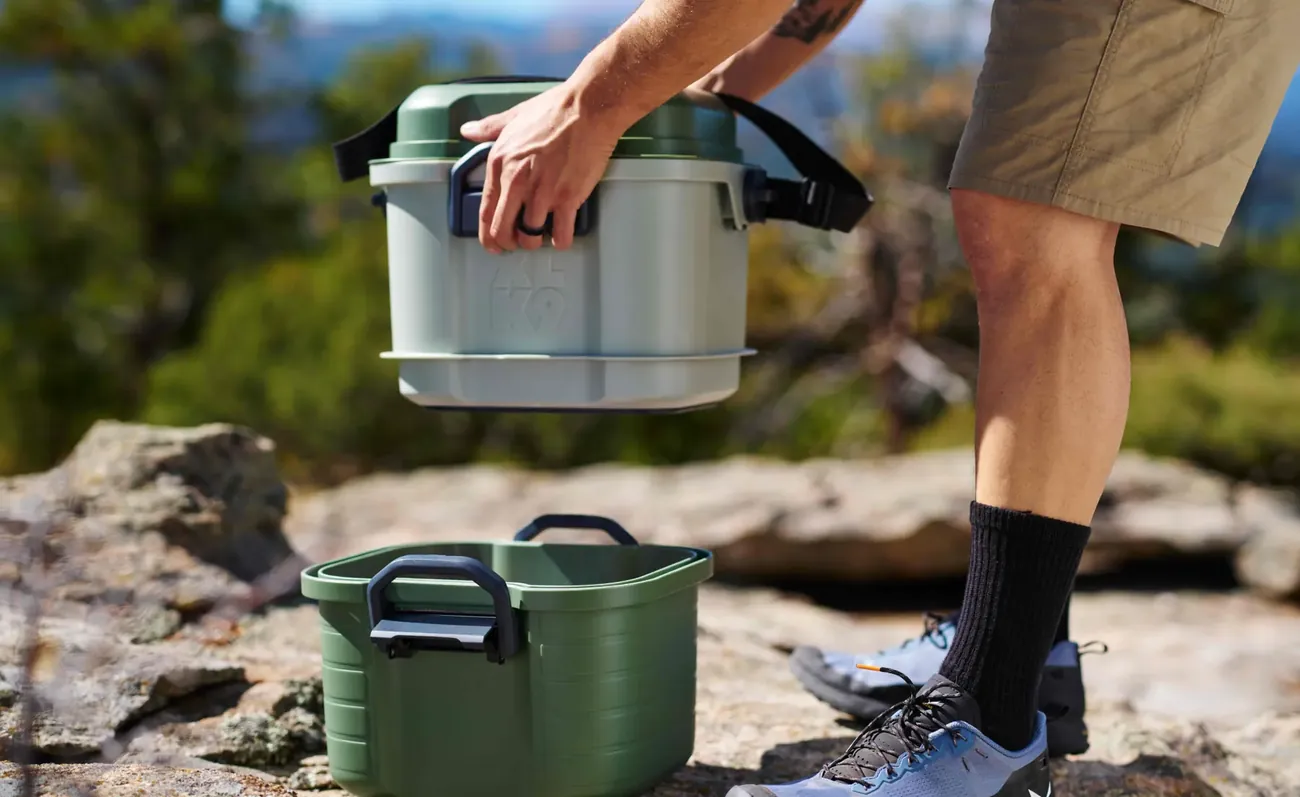 Carrying an XLK9 Basecamp unit across a rocky overlook.
